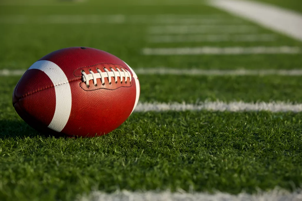 americanfootballonthefieldnearthehashmarksoryard