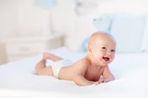 babyboywearingdiaperinwhitesunnybedroom-newbornchild