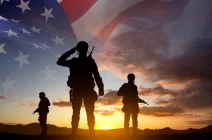 silhouettesofasoldierswithusaflagagainstthesunset