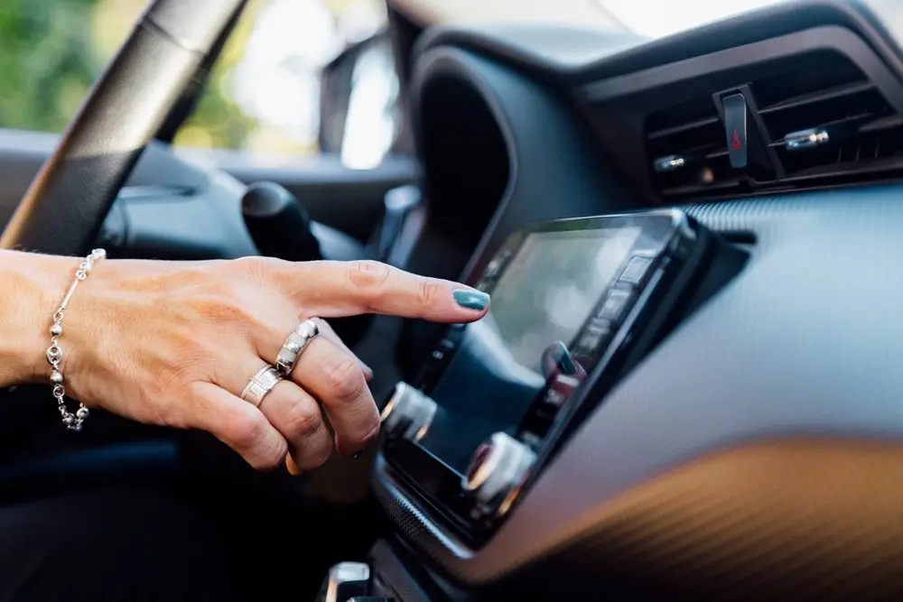 womanshandpressingthetouchscreeninhercar-selects
