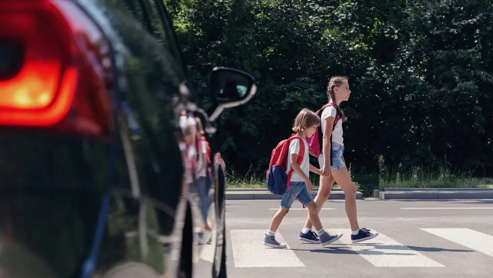 childrennexttoacarwalkingthroughpedestriancrossingto