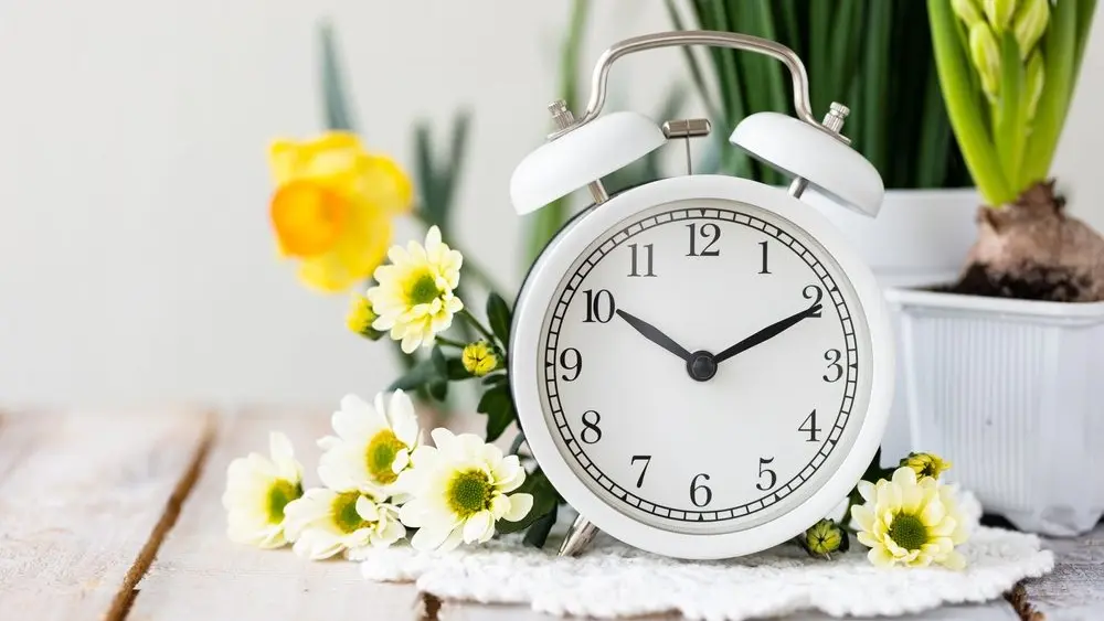 springchangedaylightsavingtimeconcept-whitealarmclockand