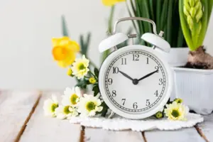 springchangedaylightsavingtimeconcept-whitealarmclockand