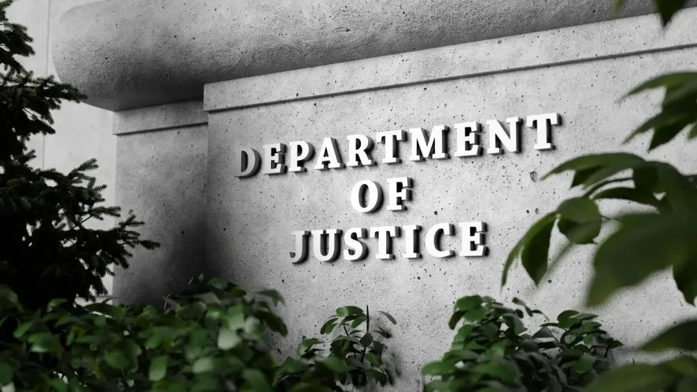 Silver sign of Department of Justice on a classical concrete wall with plants as foreground. 3D illustration of the concept of enforcement of federal laws