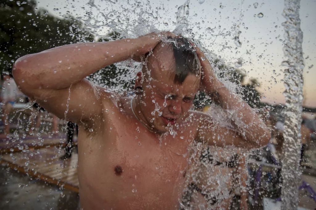 a-man-takes-a-shower-at-the-woodstock-festival-in-kostrzyn-upon-odra-river