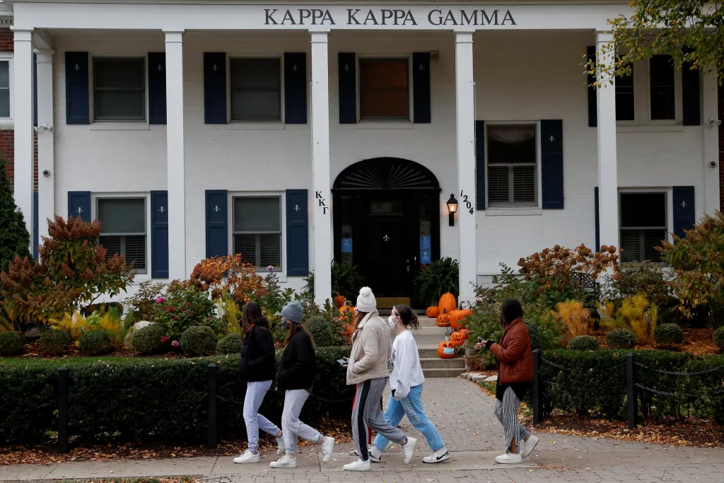 women-wearing-protective-face-masks-walk-past-a-sorority-house-on-the-university-of-michigan-campus-in-ann-arbor