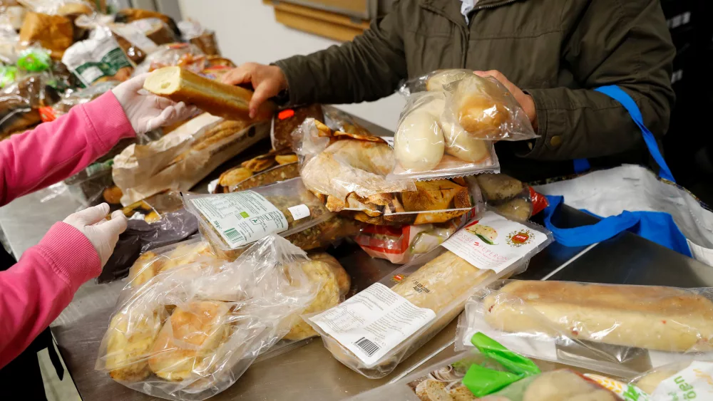 a-woman-receives-bread-at-the-non-profit-potsdamer-food-bank-potsdamer-tafel-that-offers-food-to-low-income-and-indigent-individuals-donated-by-supermarkets-and-stores-in-potsdam