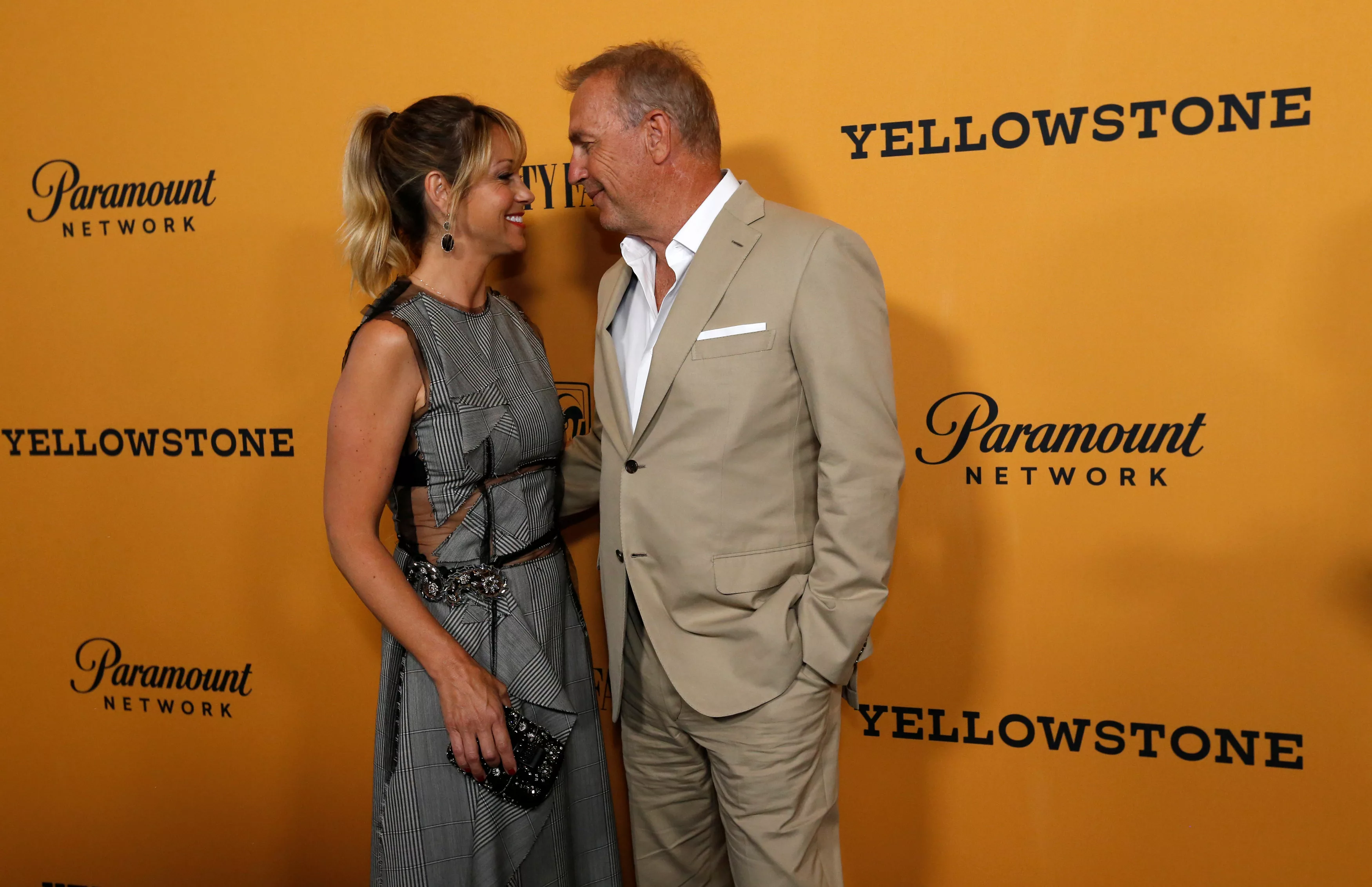 cast-member-costner-and-his-wife-baumgartner-pose-at-a-premiere-for-the-television-series-yellowstone-in-los-angeles