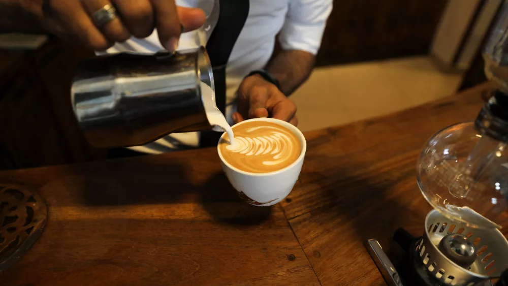 an-employee-pours-milk-into-a-cup-of-coffee-at-the-durar-specialty-coffee-store-in-sanaa