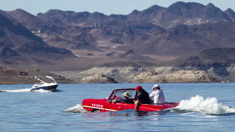 a-speedboat-passes-by-a-1963-amphicar-driven-by-rob-vondracek-of-fountain-hills-arizona-during-the-first-las-vegas-amphicar-swim-in-at-lake-mead-near-las-vegas