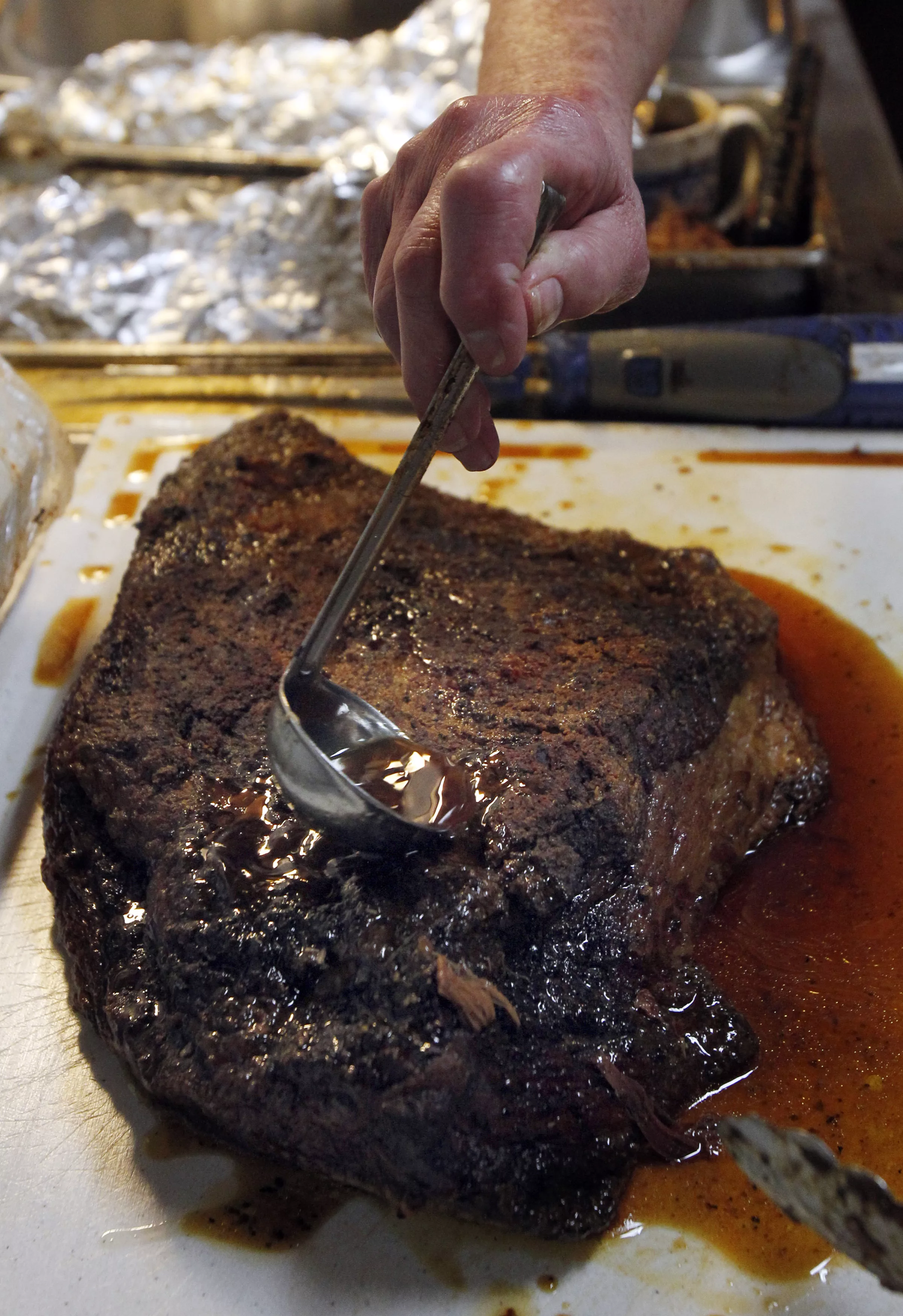 leon-uses-a-ladle-to-brisket-juice-on-a-beef-brisket-fresh-off-the-smoker-at-big-boys-bar-b-que-in-sweetwater-2