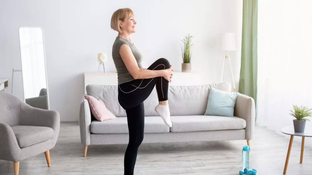 domestic-sports-concept-athletic-mature-woman-in-sportswear-doing-fitness-exercises-on-yoga-mat-indoors-copy-space