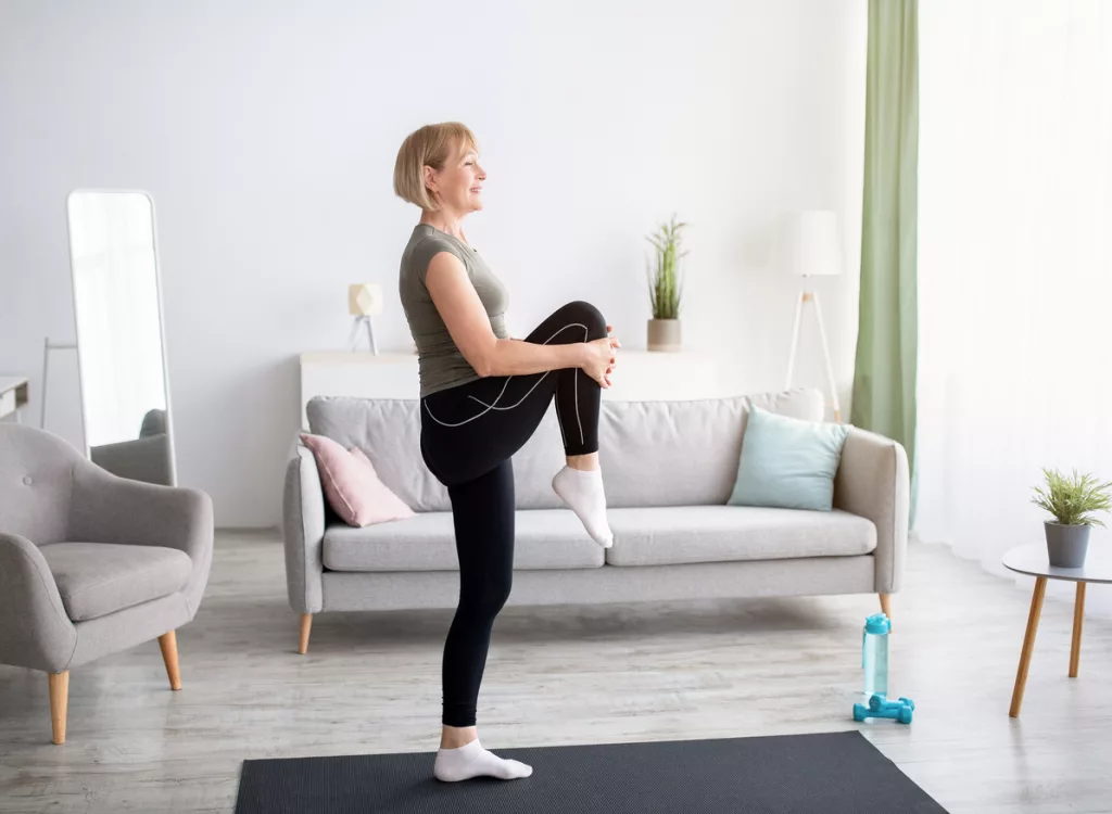 domestic-sports-concept-athletic-mature-woman-in-sportswear-doing-fitness-exercises-on-yoga-mat-indoors-copy-space