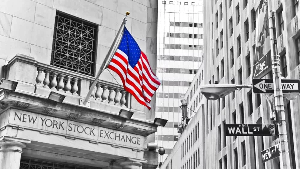 Side entrance of New York Stock Exchange and a street sign of Wall Street shown on October 11^ 2013 in New York City.