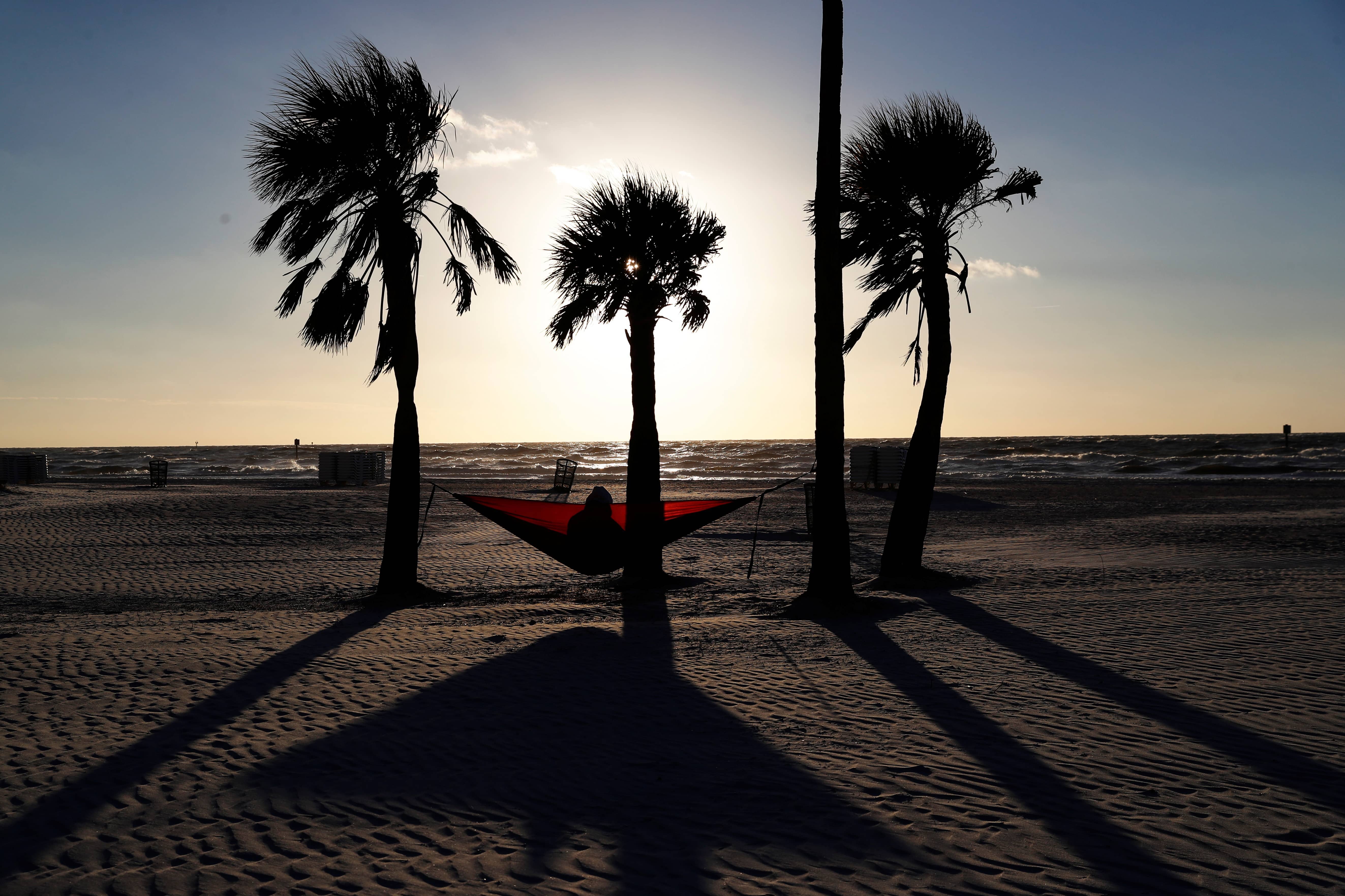 katie-burkett-sits-in-a-hammock-amid-the-spread-of-the-coronavirus-disease-covid-19-beneath-palm-trees-at-sunset-in-clearwater-beach-florida