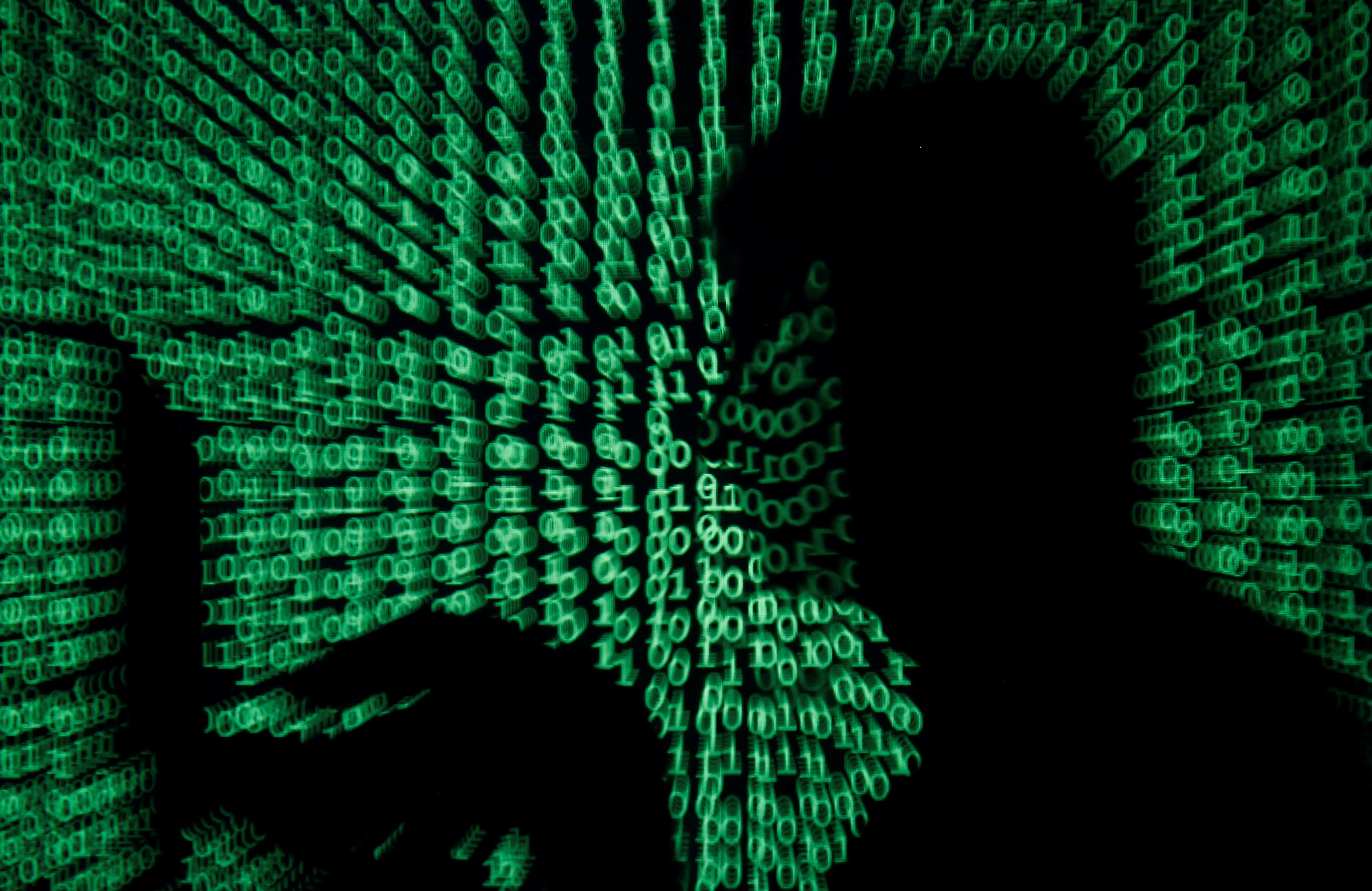 file-photo-man-holds-laptop-computer-as-cyber-code-is-projected-on-him-in-this-illustration-picture