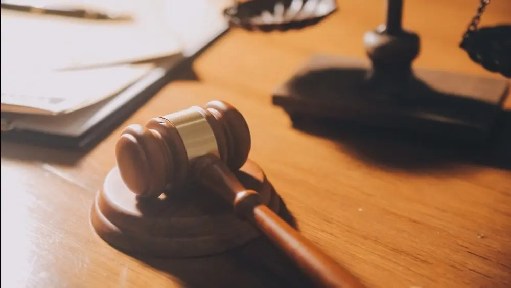 law books and scales of justice on desk in library of law firm. jurisprudence legal education concept.
