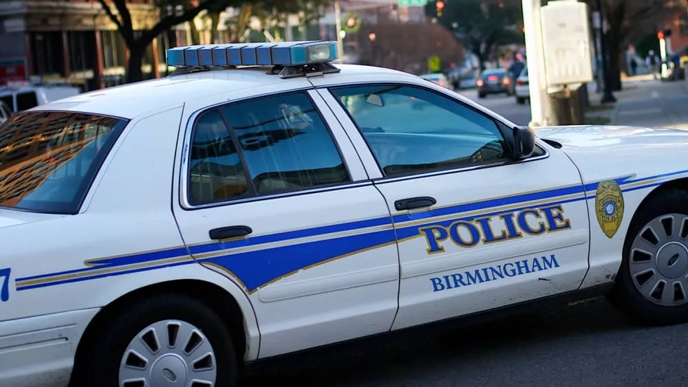 Birmingham^ Alabama / USA - April 6^ 2020: A police car turning a corner in the downtown financial district of the city.