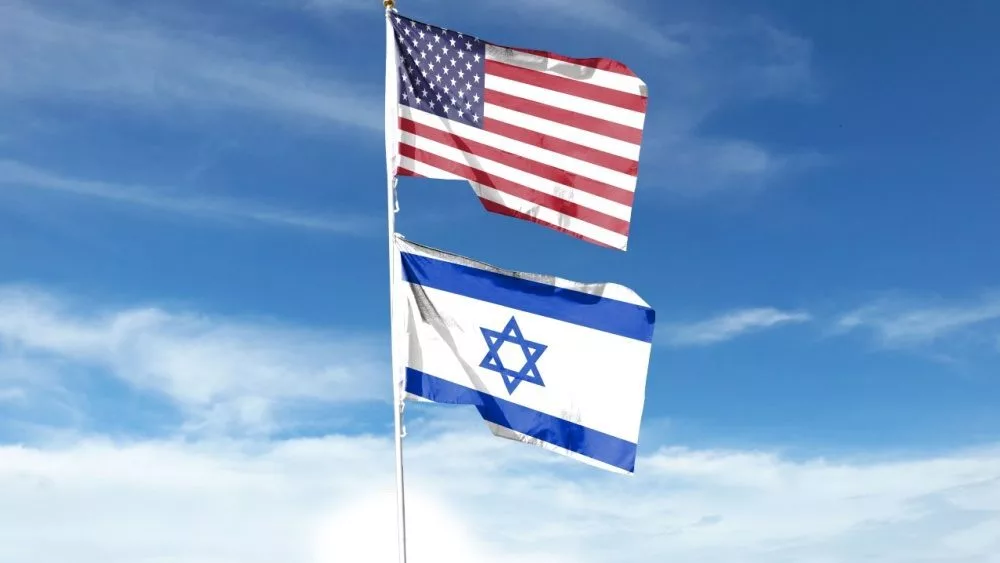 American and Israeli flags fly in the cloudy sky