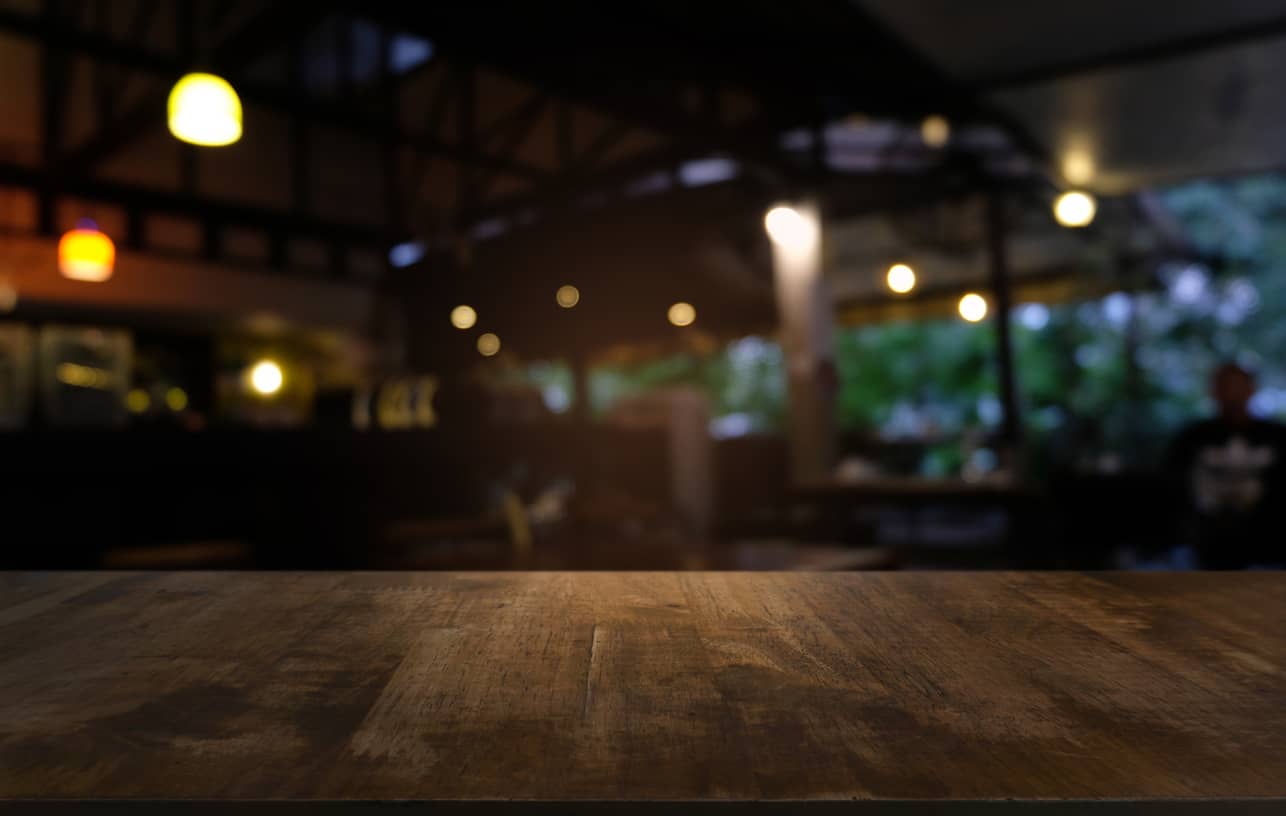 empty-dark-wooden-table-in-front-of-abstract-blurred-bokeh-background-of-restaurant-can-be-used-for-display-or-montage-your-products-mock-up-for-space