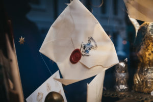 harry-potter-hogwarts-letters-on-a-retail-window-display-of-minalima-store-in-covent-garden-london-uk
