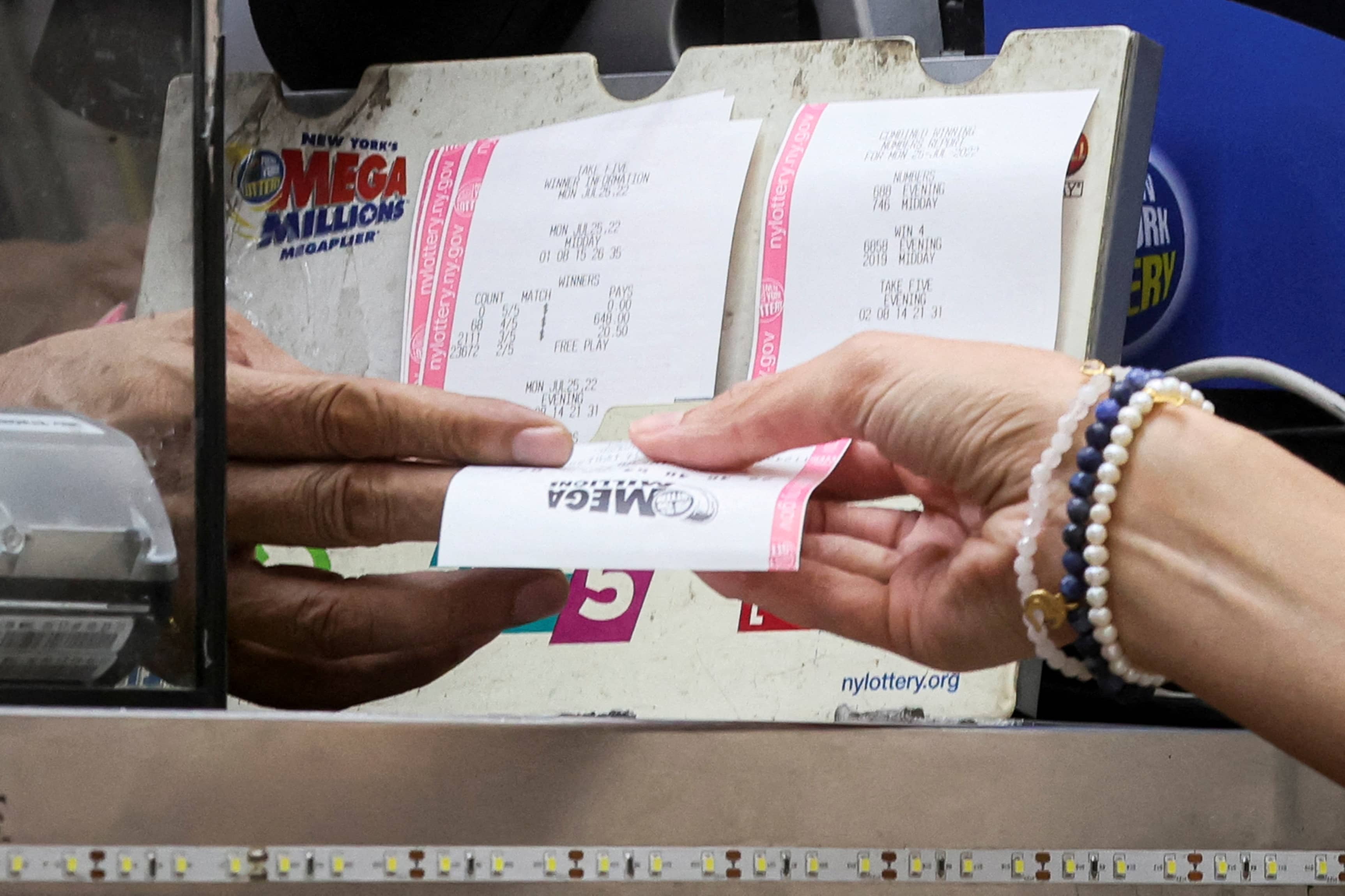 file-photo-a-woman-buys-a-ticket-for-the-mega-millions-lottery-drawing-at-a-news-stand-in-new-york