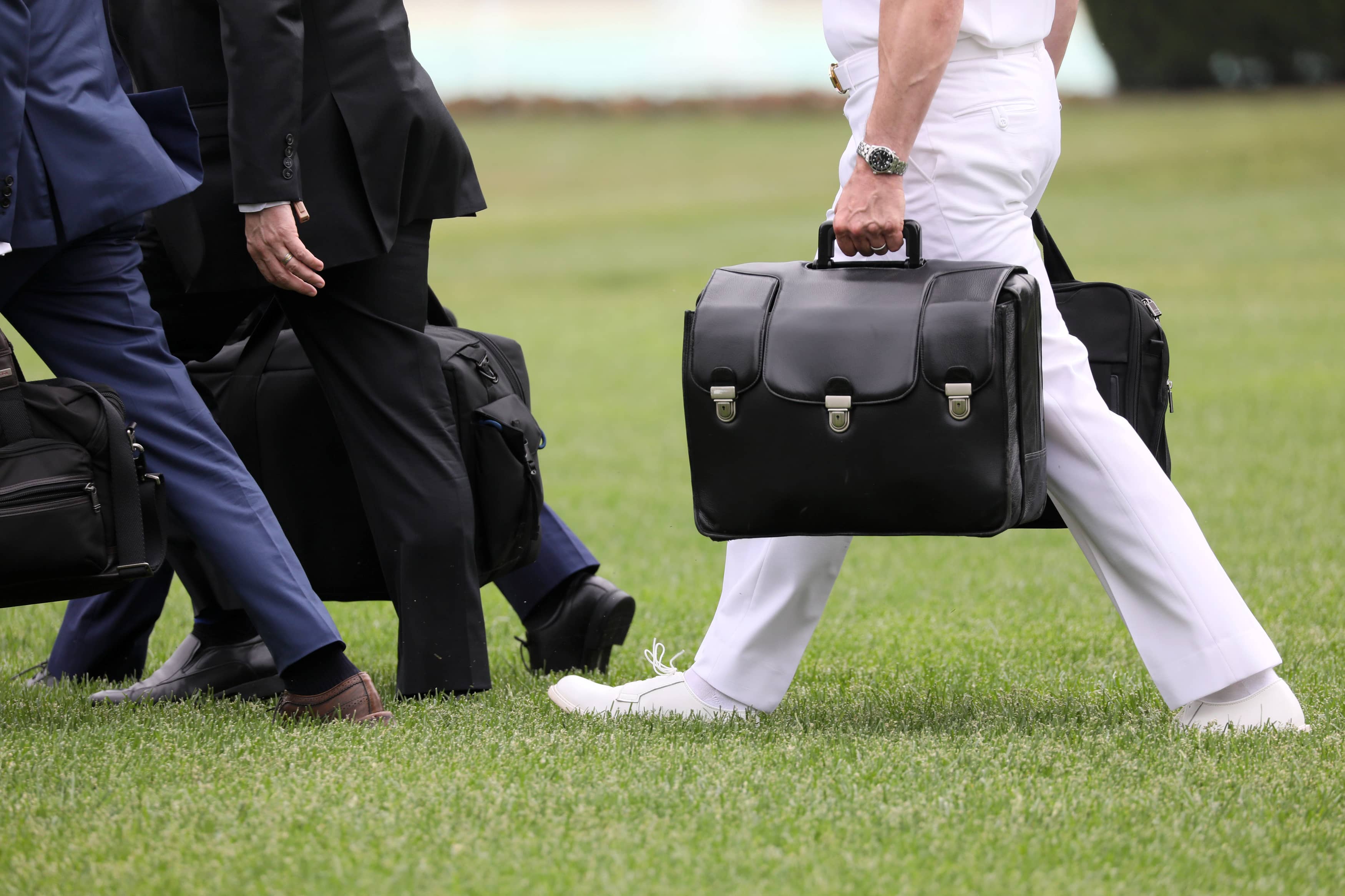 a-military-aide-carries-the-so-called-nuclear-football-as-he-walks-to-board-the-marine-one-helicopter-with-u-s-president-trump-for-travel-from-the-white-house-in-washington