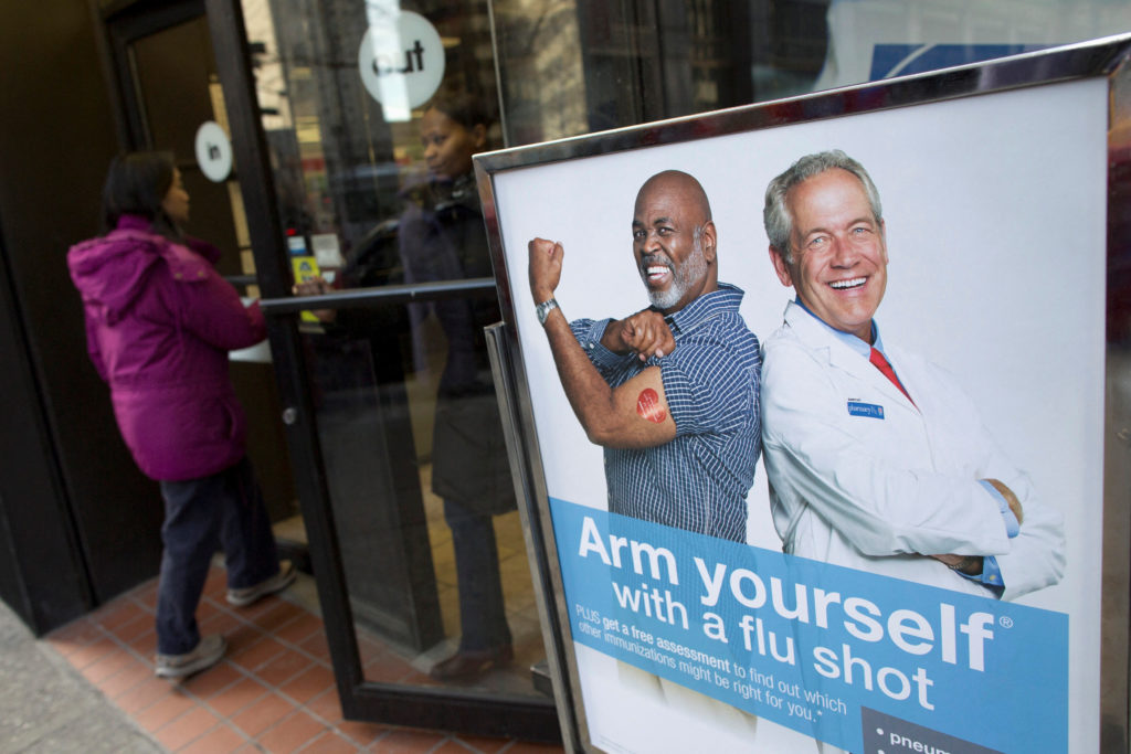 file-photo-people-enter-a-pharmacy-next-to-a-sign-promoting-flu-shots-in-new-york