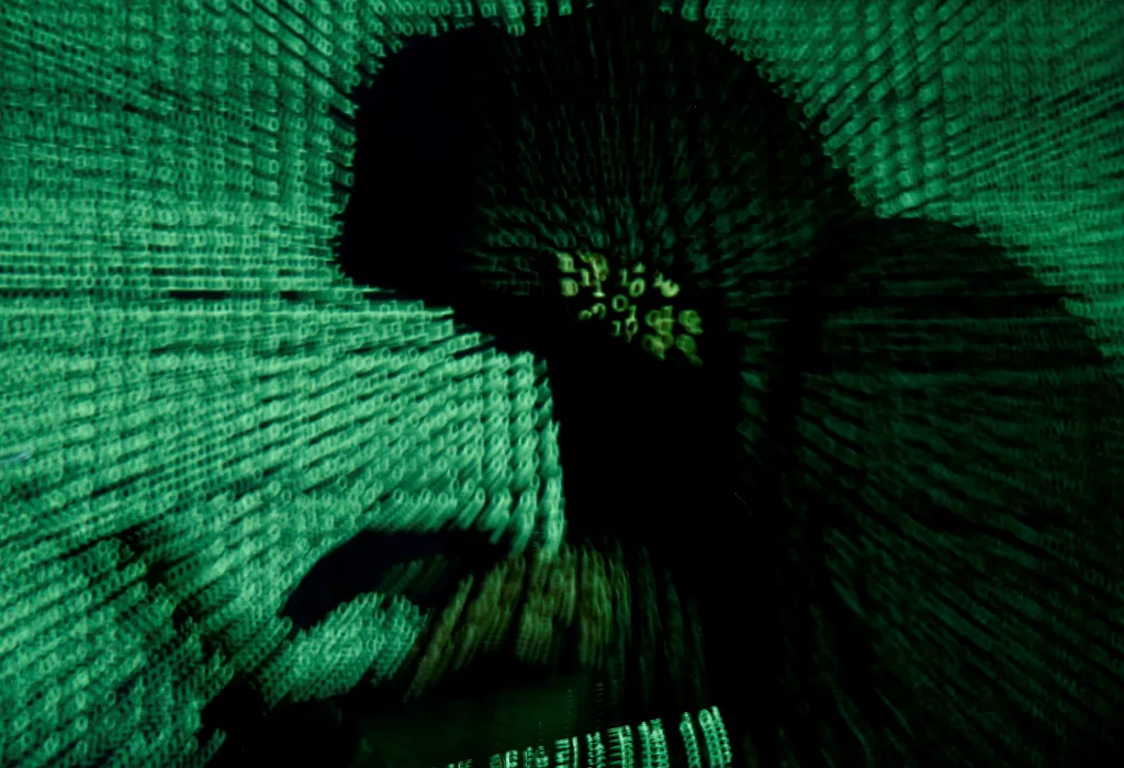 file-photo-man-holds-laptop-computer-as-cyber-code-is-projected-on-him-in-this-illustration-picture