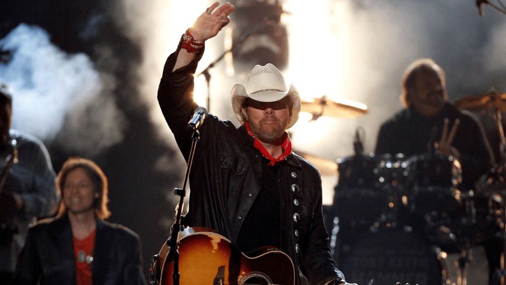 Toby Keith performing on stage in the current year, showcasing his talent and success in the music industry