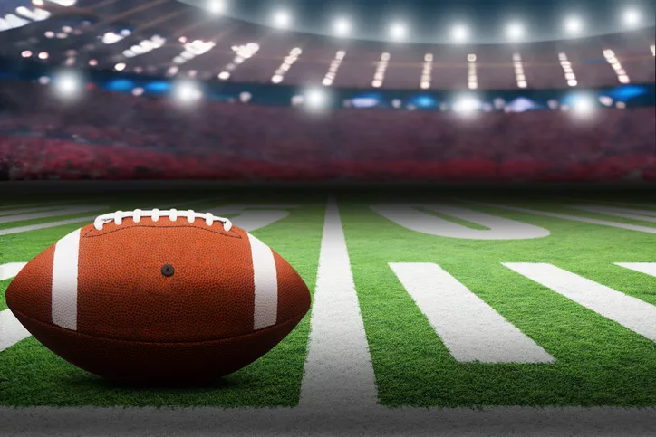 american-football-on-field-with-dramatic-spot-lights-on-ball