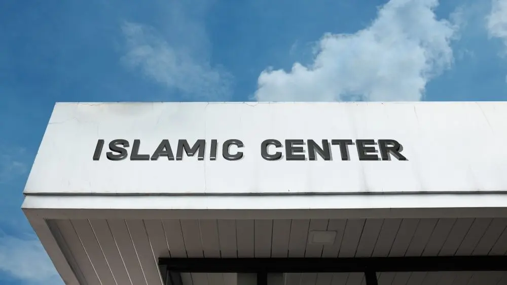 Islamic Center sign on a community building under blue sky^ symbolizing worship^ cultural education^ Muslim community services^ faith^ and spiritual guidance