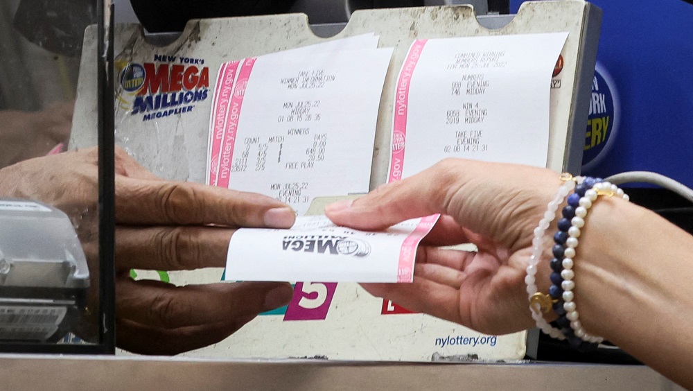 a-woman-buys-a-ticket-for-the-mega-millions-lottery-drawing-at-a-news-stand-in-new-york-2