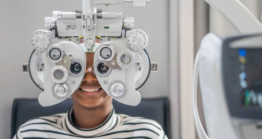 close-up-of-african-teen-girl-doing-eye-test-on-phoropter-african-teen-girl-checking-on-her-eye-with-optometry-machine