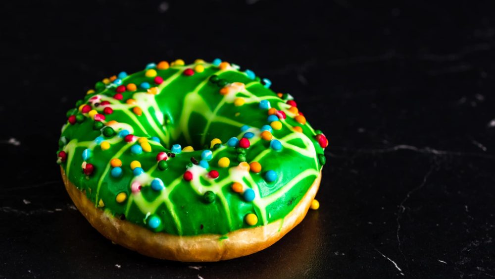 green-glazed-donut-with-sprinkles-isolated-close-up-of-colorful-donut