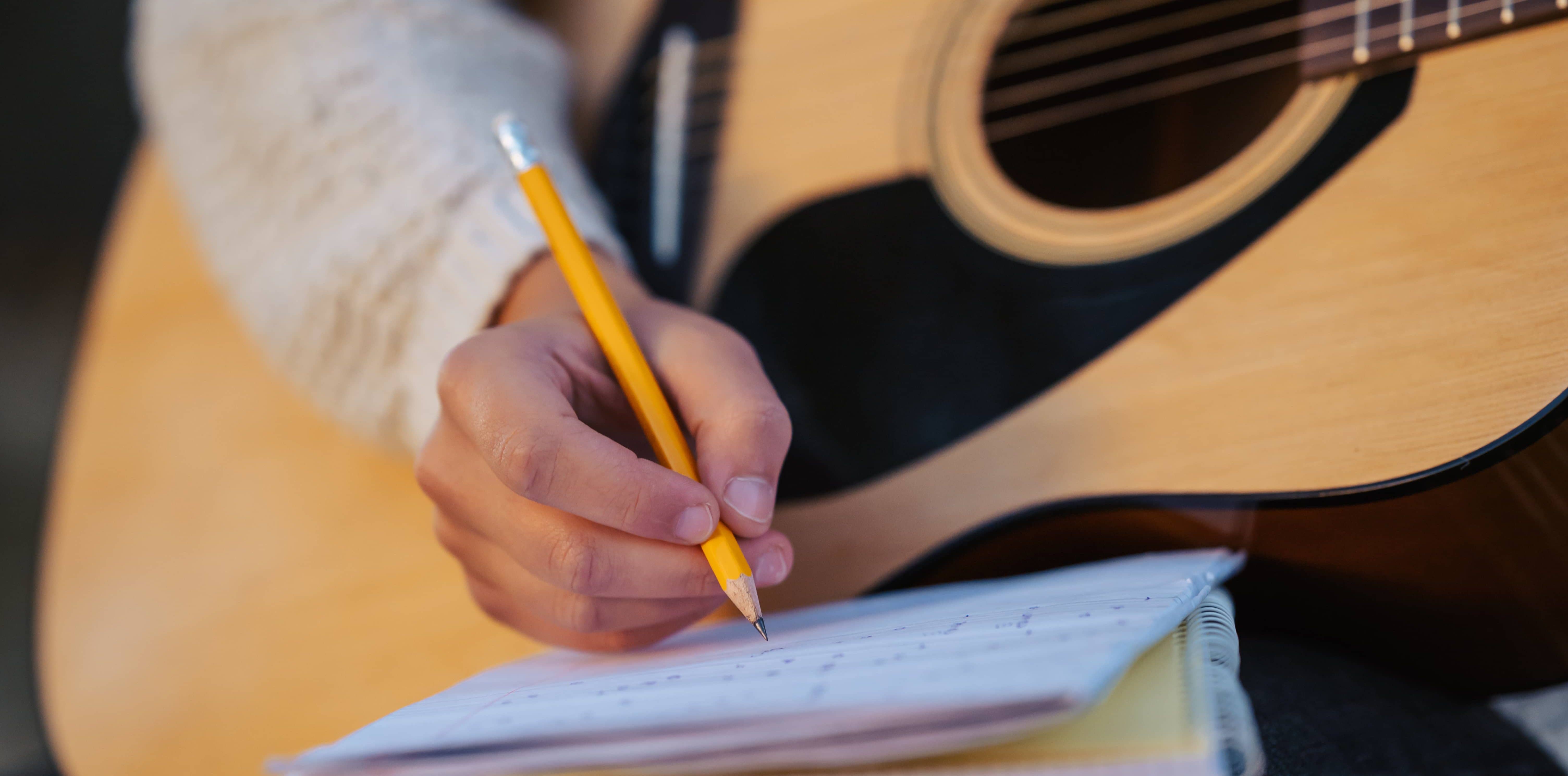 close-up-of-a-girl-musician-composing-song-writing-down-chords-to-the-notes