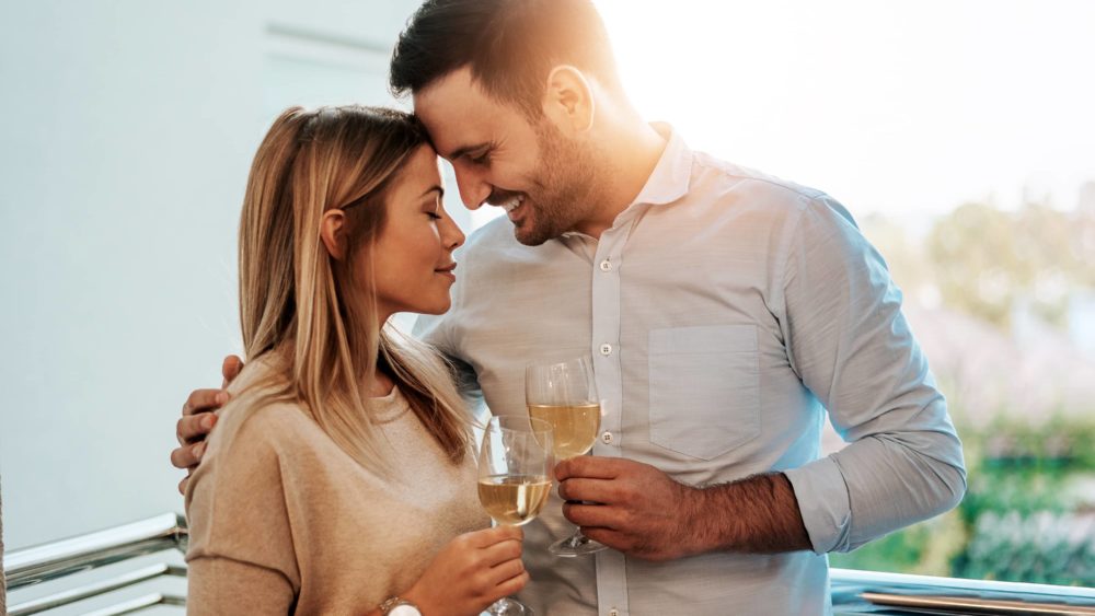 image-of-a-lovely-couple-drinking-white-wine-while-hugging