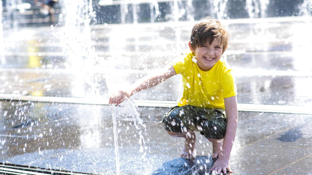 happy-child-plays-in-a-dry-fountain-joyful-smiling-wet-boy-in-the-fountain
