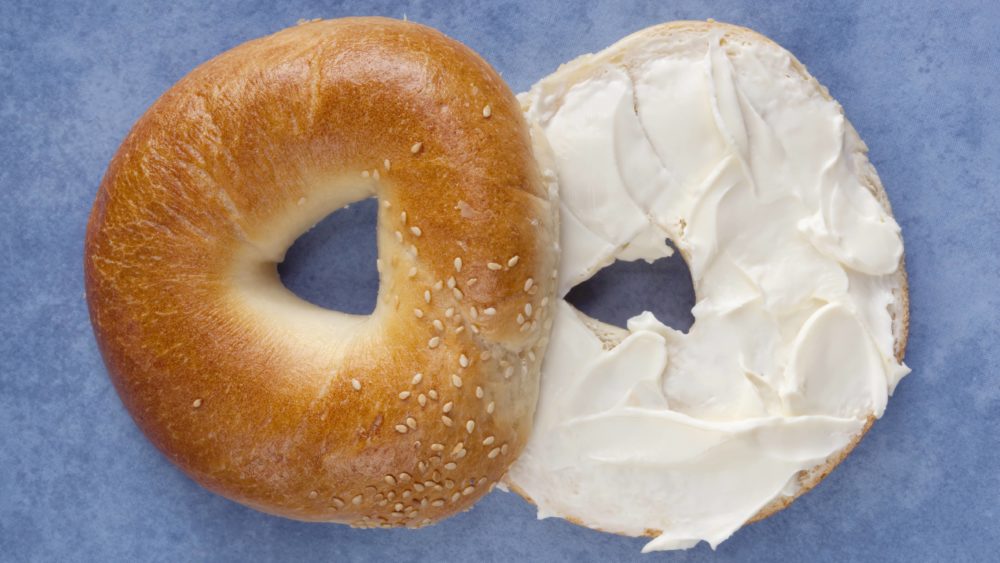 a-sliced-bagel-spread-with-cream-cheese