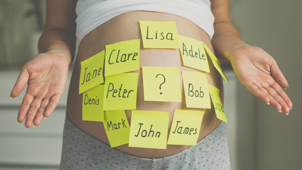 toned-shot-of-pregnant-woman-with-child-names-on-belly