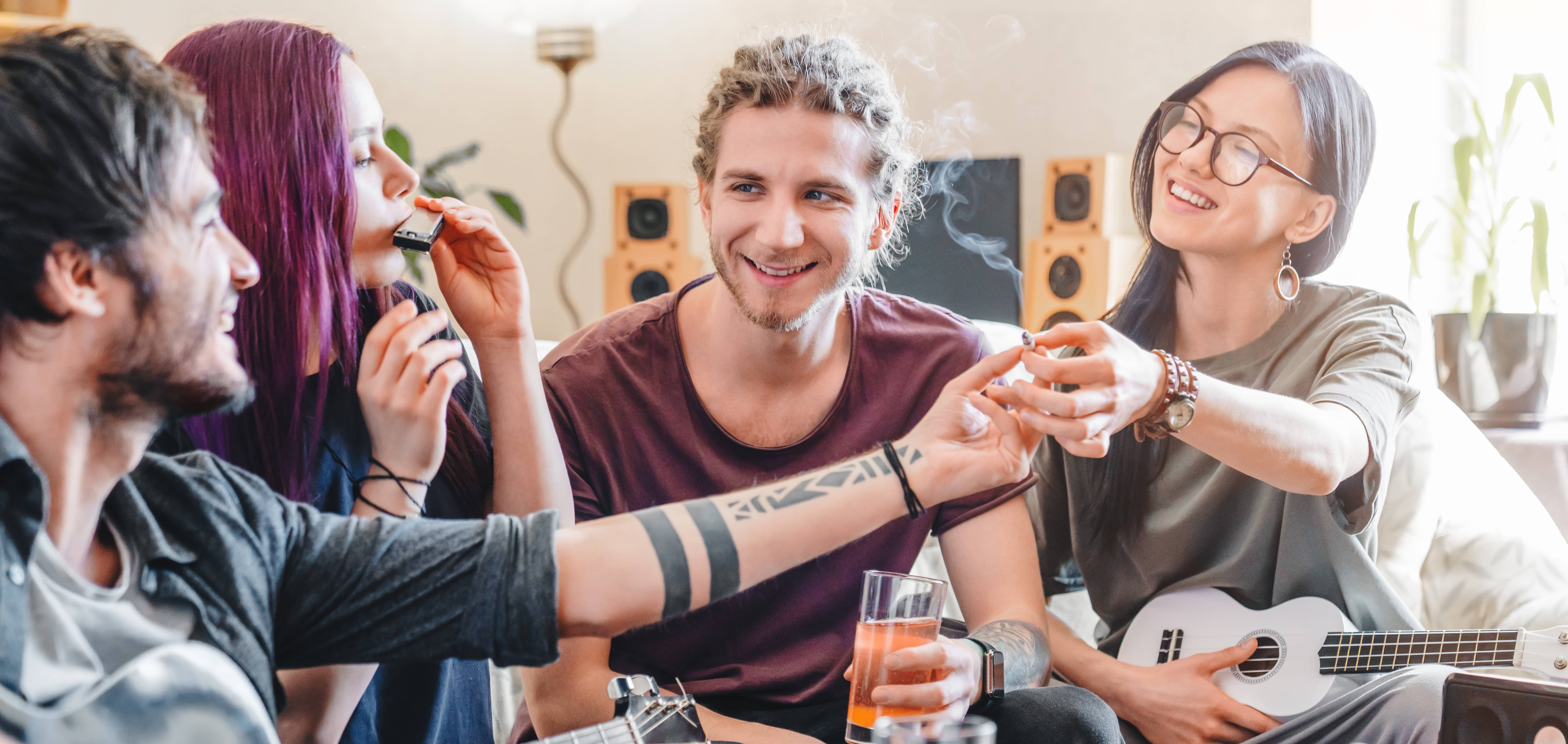 young-woman-preparing-to-smoke-joint-with-cannabis-while-relaxing-with-friends-at-home