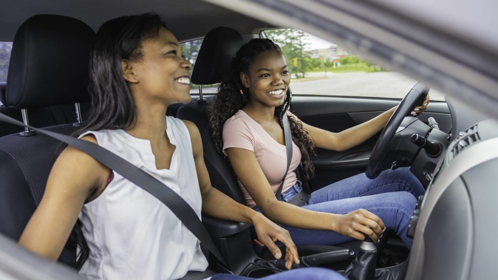 young-black-teenage-driver-seated-in-her-new-car-with-her-mother