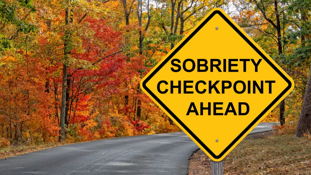 sobriety-checkpoint-ahead-warning-sign-autumn-background