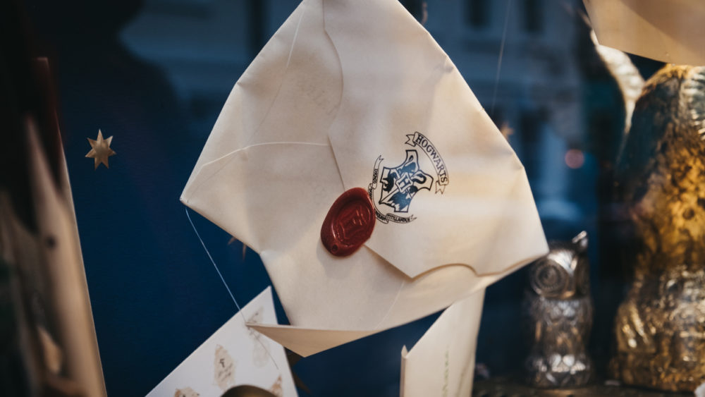 harry-potter-hogwarts-letters-on-a-retail-window-display-of-minalima-store-in-covent-garden-london-uk