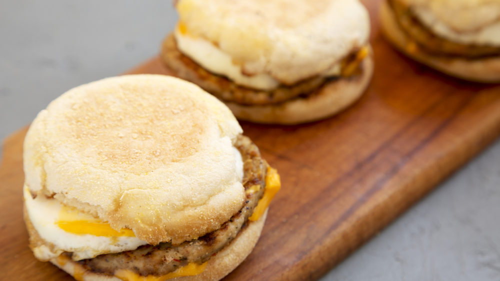 homemade-pork-roll-egg-sandwich-on-a-rustic-wooden-board-on-a-gray-surface-side-view-close-up