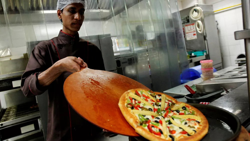 file-photo-a-cook-slides-a-pizza-onto-a-serving-plate-in-the-kitchen-at-a-pizza-hut-restaurant-in-mumbai-march-29-2011