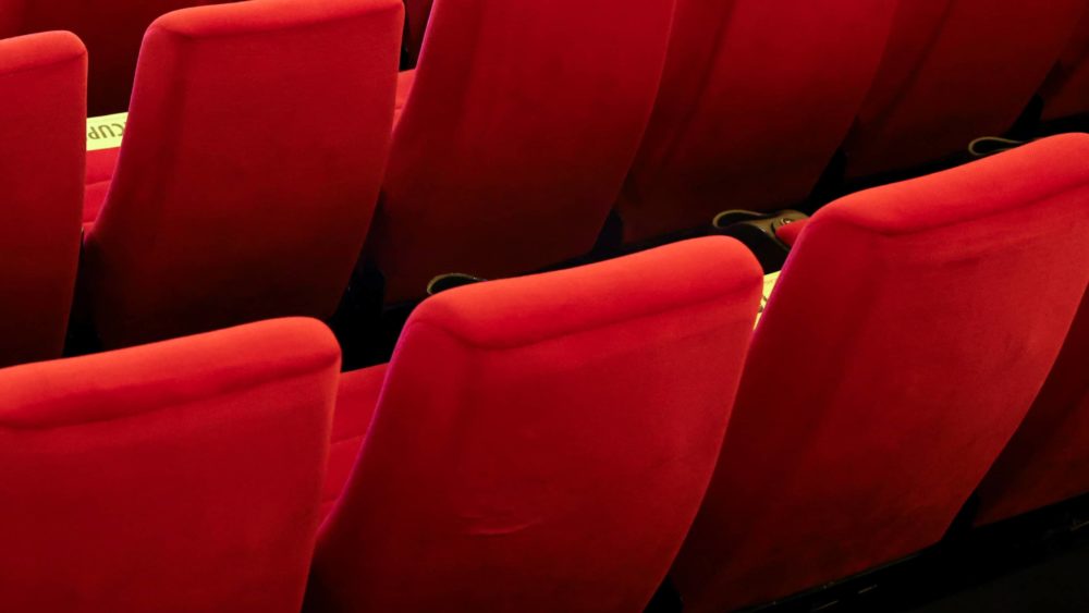 a-worker-wearing-personal-protective-equipment-sanitizes-seats-inside-a-movie-theatre-ahead-of-its-reopening-in-mumbai