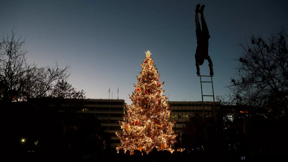 a-street-artist-performs-in-front-of-the-christmas-tree-at-syntagma-square-during-christmas-festivities-in-athens
