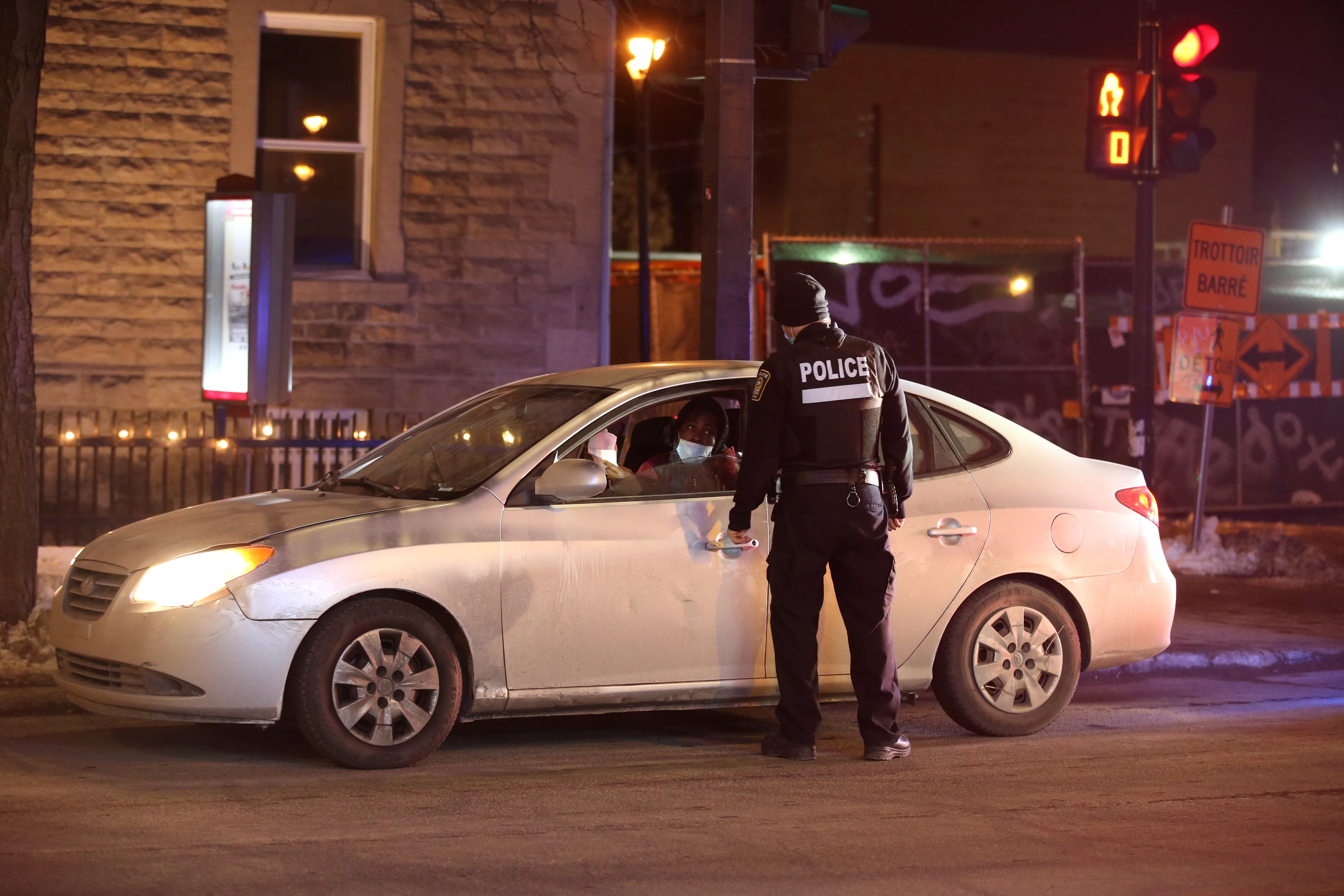 police-ticket-a-vehicle-as-they-enforce-a-night-curfew-imposed-by-the-quebec-government