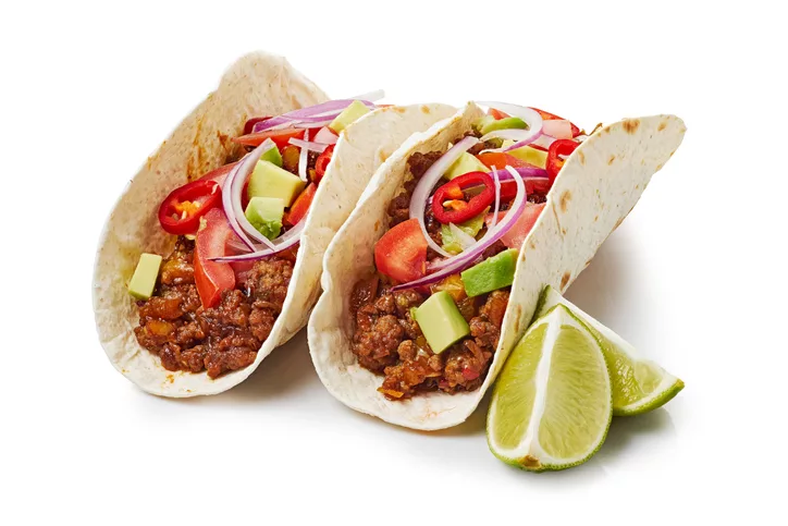 two-tacos-with-ground-beef-and-lime-on-white-background